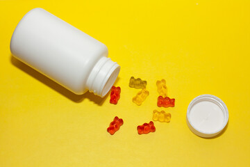 jar of children's vitamins colored jelly bears on a yellow background