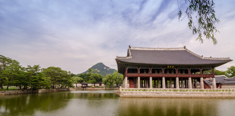 Fototapeta premium Gyeongbokgung Palace during cloudy summer day. Korean text translated to English means Gyeonghoeru, which is name of pavillion.