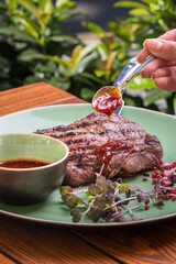 grilled beef steak with spices on a knife Food on plate. Restaurant menu concept. Copy space.