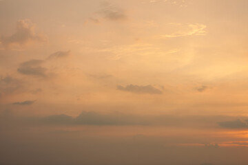 Warm foggy sunset sky with pastel romantic clouds, last rays of sun on the horizon before sunset