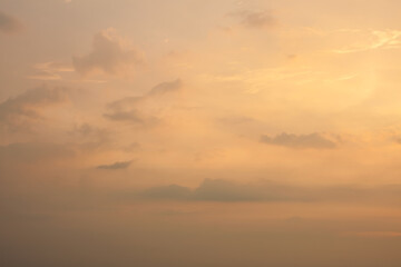 Fototapeta na wymiar Warm foggy sunset sky with pastel romantic clouds, last rays of sun on the horizon before sunset