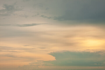Warm foggy sunset sky with pastel romantic clouds, last rays of sun on the horizon before sunset