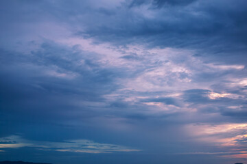 Stormy heavy violet sky with dark rainy gloomy dramatic clouds surrounded by hazy mystical...