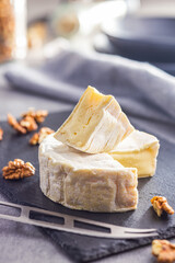 Brie type cheese with white mold. French camembert cheese on cutting board.