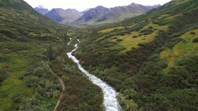 ALASKA - 2023 - Excellent aerial footage passing over a river in Alaska's Hatcher Pass and heading towards the mountains.