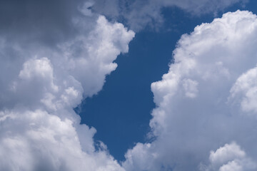 There is a large, cumulus cloud in the blue sky. Close-up - obrazy, fototapety, plakaty