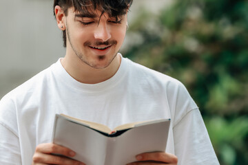 young man with book on the street outdoors