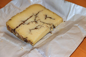 Piece of truffle cheese on a wooden table