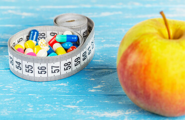 Diet for weight loss apples or pills with measuring tape