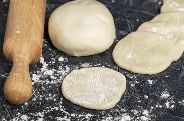 ball of fresh raw dough, flour and rolling pin top view