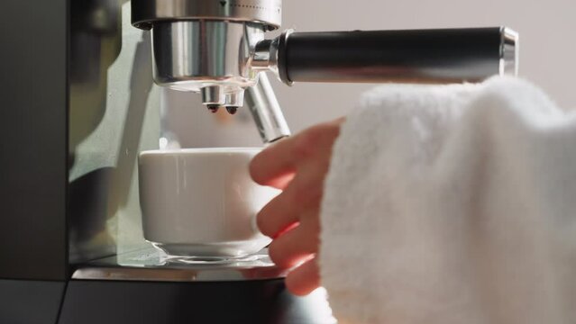 Lady brews beverage with coffee machine