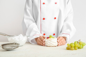 Female confectioner with tasty cake on white background