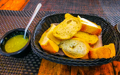 Bread in basket and green coriander sauce restaurant Mexico.