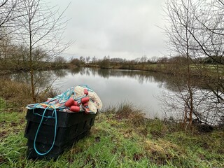Fishing equipment floats and nets by a lake in the English countryside