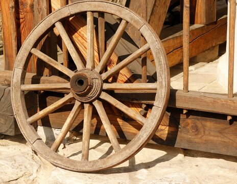 Old wooden hand-wrought cart wheel.