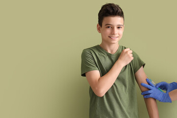 Little boy receiving vaccine on green background