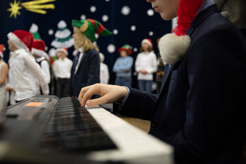 Christmas musican performance of children in school with keyboard. Kids play and dance on a stage with music. Concert of people.
