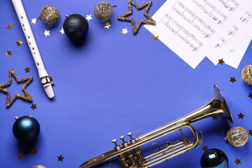 Flute and trumpet with Christmas decorations and notes on purple background