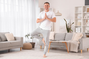 Mature man doing yoga at home