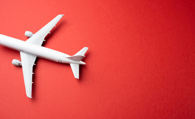 White passenger airplane on a red background. Booking flight tickets. Planning your trips....