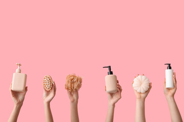 Female hands with different bath supplies on pink background