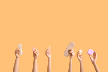 Female hands with different feminine hygiene products on color background