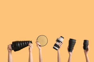 Female hands with modern photographer's equipment on color background