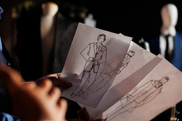Extreme close up of sketch drawings in tailoring studio showing cool stylish clothing. Skilled...