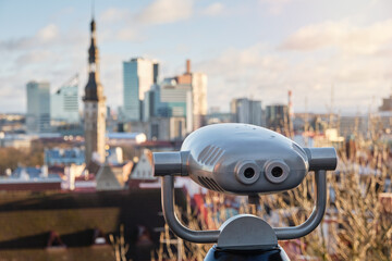 Binocular viewer on observation deck, tourist telescope for exploring cityscape of Tallinn. ...