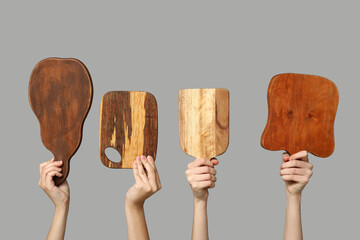 Female hands with wooden cutting boards on grey background