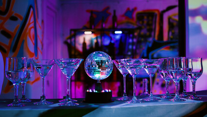 Empty bar with alcohol drinks in glasses, nightclub with disco lights and music in discotheque....