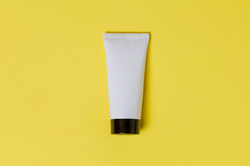White sunscreen bottle on yellow background. Mockup. Sunscreen concept. Beauty product concept. Space for text. Mockup.