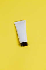 White sunscreen bottle on yellow background. Mockup. Sunscreen concept. Beauty product concept. Space for text. Mockup.