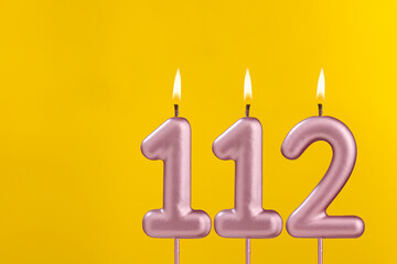Birthday candle number 112 - Birthday celebration on yellow background