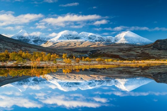 Reflection of the autumn landscape in Rondane National Park, snow-capped mountains, Doraldalen, Norway, Europe