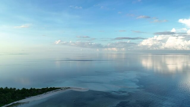 A serene sunrise illuminates the remote island of Koon near Seram, Indonesia. This scenic island's coral reefs, and the surrounding seas, support extraordinary marine biodiversity.