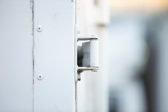 Close up of white metal door handle with shallow depth of field.