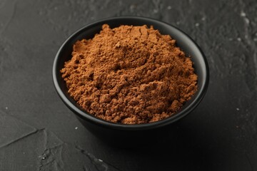 Aromatic cinnamon powder on black table, closeup