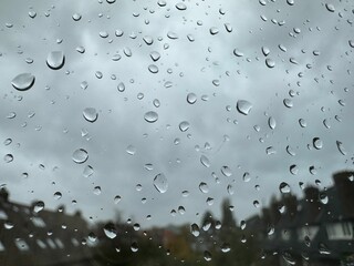 Window with water droplets on rainy day, closeup