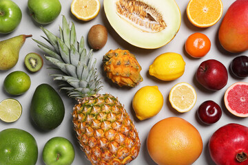 Many different fresh fruits on light grey table, flat lay