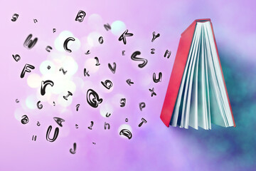 Book and flying letters on lilac background, top view. Bokeh effect