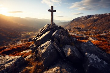 Cross on a rock in the mountains at sunrise, golden hour. Religion concept.

