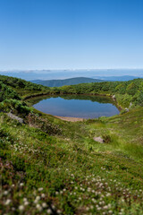 Fototapeta na wymiar clear ponds reflecting the sky above three tree line on mount asahidake