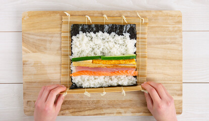 Makizushi, Sushi rolls, Rolled sushi. A woman making sushi rolls. Ehomaki, seafood rolls, Setsubun,...