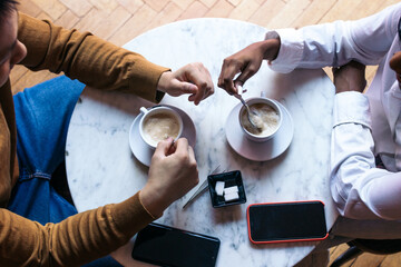 Overhead shot of two people on a date drinking coffee