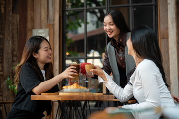 A group of trendy, happy Asian girls are drinking and enjoying talking in a cafe in the city.