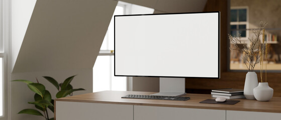 A computer desk in a modern, minimal private office room with a white-screen PC computer on a desk.