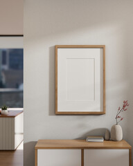 Front view of a wooden picture frame mockup hanging on a white wall and a minimal wooden drawer.