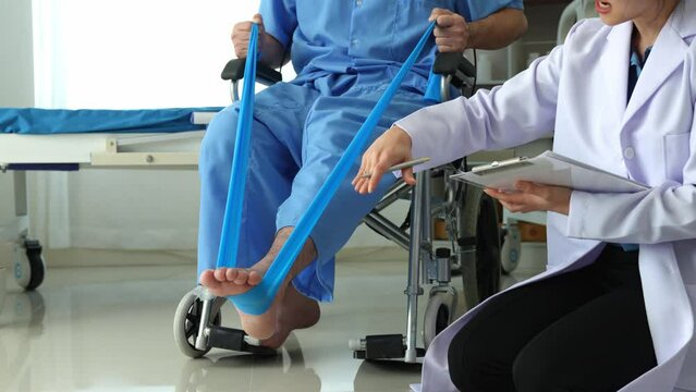 A physical therapist gives resistance band exercises. About the leg and ankle of male office workers, office syndrome, and male patients. Physiotherapy concept.