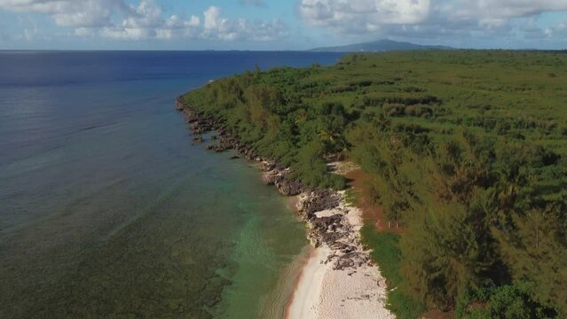 Tilt up shot of a drone revealing a tropical beach at Tinian, Northern Mariana Islands